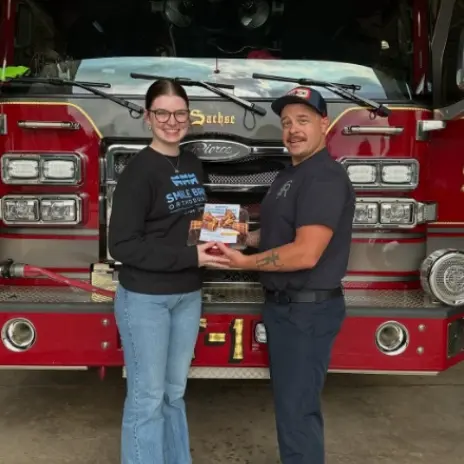 people smiling in front of a firetruck