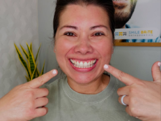 woman smiling pointing at teeth
